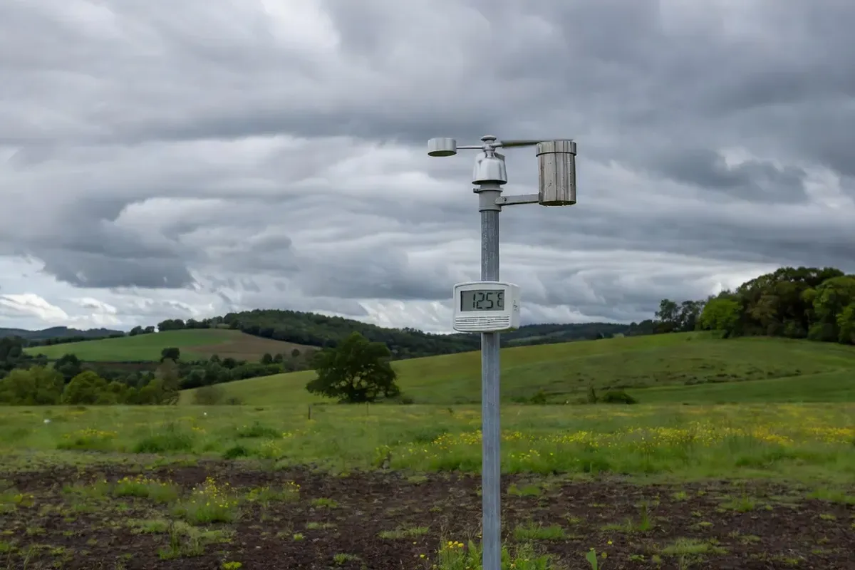 Station météo professionnelle avec anémomètre et pluviomètre dans un champ de Franche-Comté